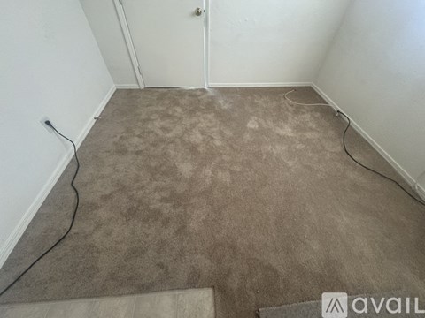 A room with a carpet and a door.