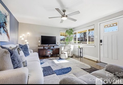 A living room with a white couch and a television on a wooden stand.