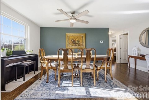 A dining room with a wooden table and chairs.