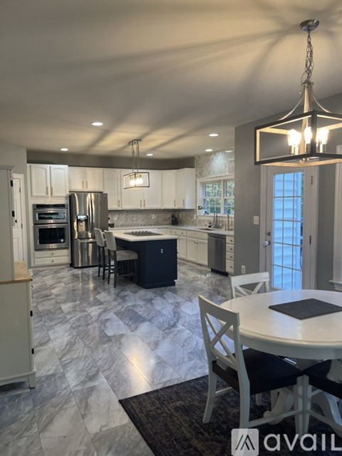 A modern kitchen with a dining table and chairs.