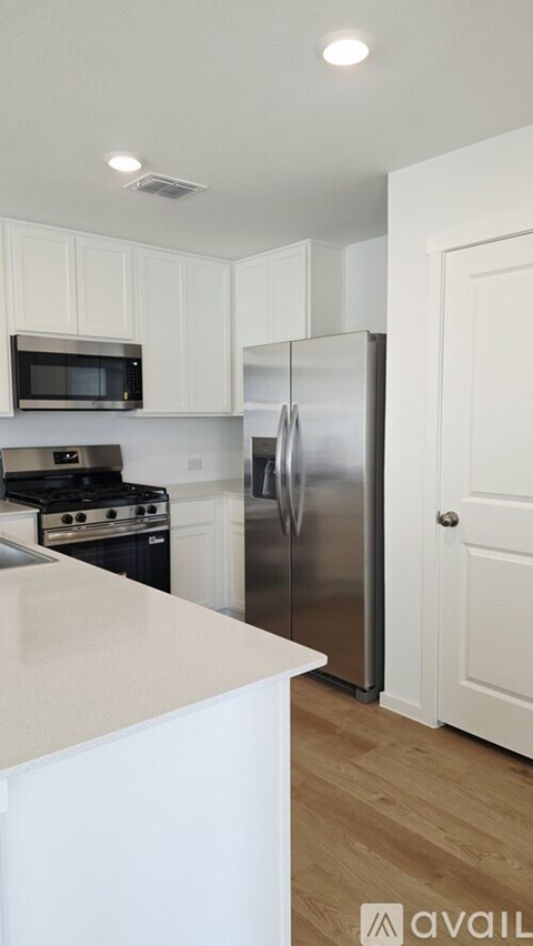 A kitchen with a stainless steel refrigerator, microwave, and oven.