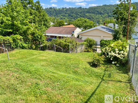 A backyard with a fence and a house in the background.