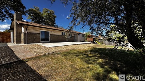 A house with a driveway and trees in the background.