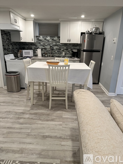 A kitchen with a dining table and chairs.