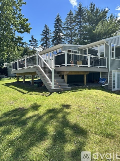 A house with a deck and stairs leading to it.