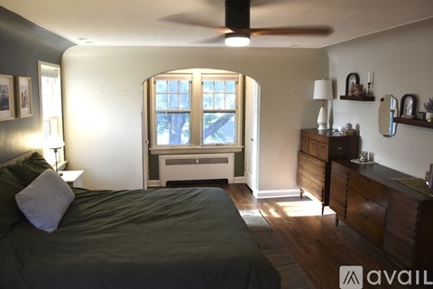 A bedroom with a bed, dresser, and window.