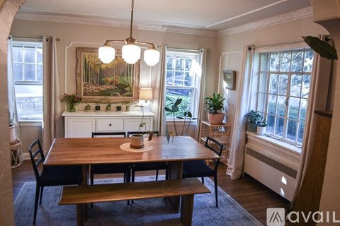 A dining room with a wooden table and chairs.