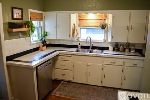 A kitchen with white cabinets and a black countertop.