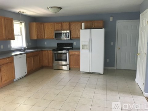 A kitchen with wooden cabinets and white appliances.