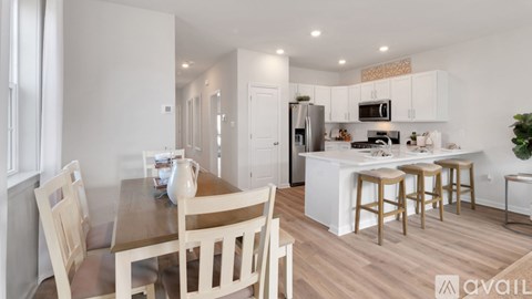 A kitchen with a dining table and chairs.