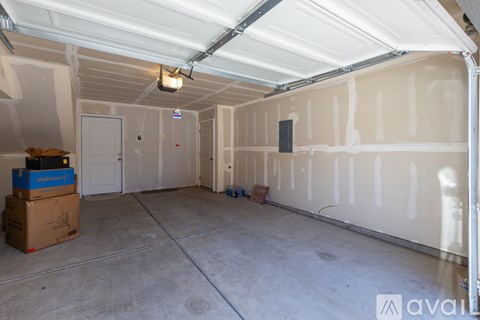 A sparsely furnished garage with a white ceiling and walls.