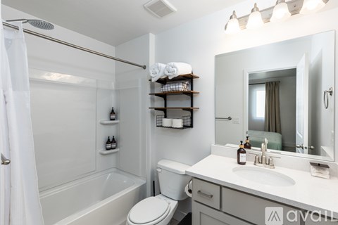 A white bathroom with a toilet, sink, and shower.
