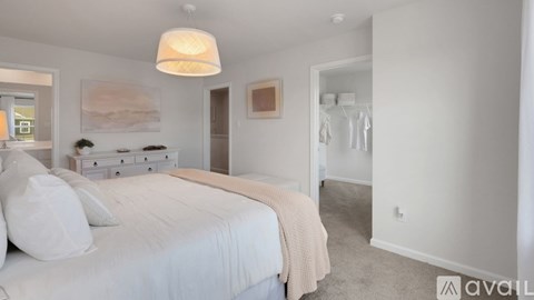 A bedroom with a large bed and a painting on the wall.