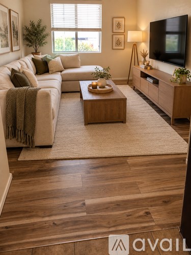 A living room with a couch, coffee table, and television.