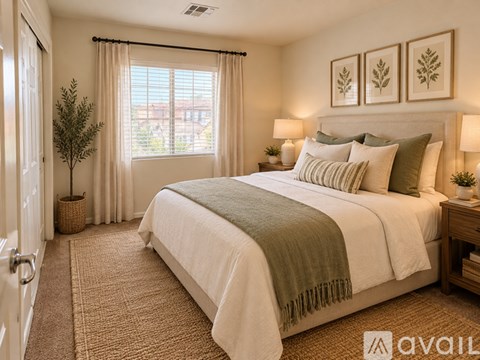 A bedroom with a large bed and a window with curtains.