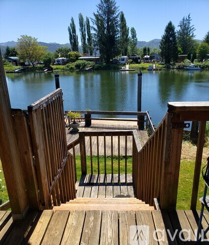 A wooden deck overlooks a lake with a mountain in the distance.