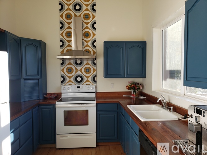 A kitchen with a white oven and blue cabinets.