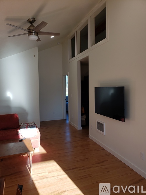 A living room with a television and a fan.