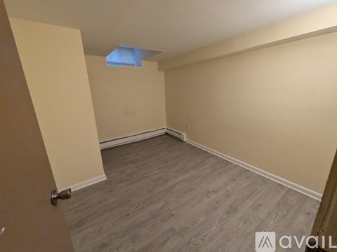 A room with a wooden floor and a door on the left.