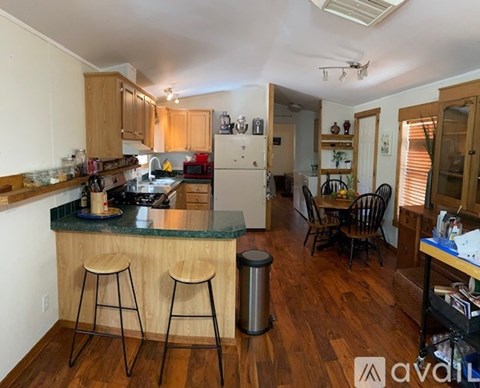A kitchen with wooden cabinets and a green island.