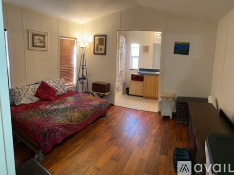 A bedroom with a bed, a nightstand, and a window with curtains.