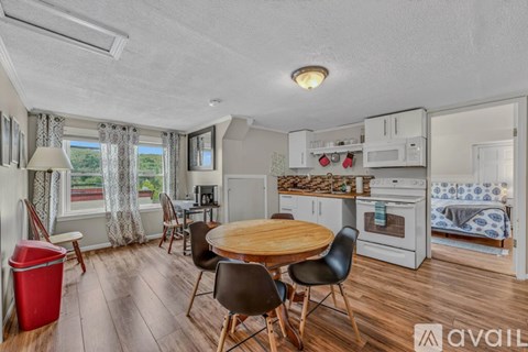 A kitchen with a table and chairs in front of a window.