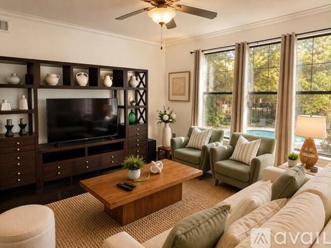 A living room with a television, couches, and a ceiling fan.