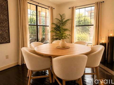 A dining room with a round table and chairs.