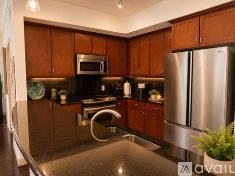 A kitchen with brown cabinets and a stainless steel refrigerator.
