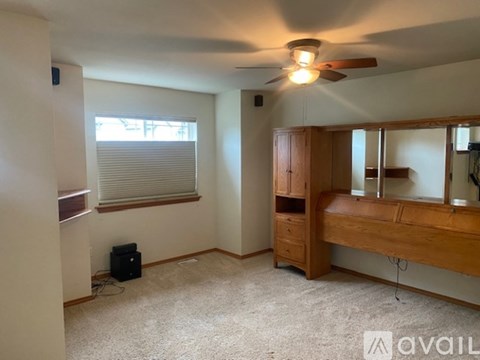 A bedroom with a bed, dresser, and window with blinds.