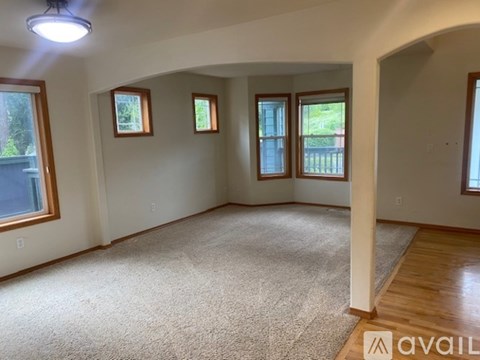 A spacious room with a carpeted floor and a large window.