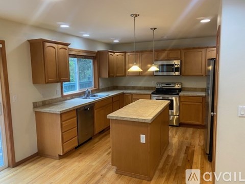 A kitchen with wooden cabinets and a central island.