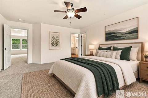 A bedroom with a large bed and a ceiling fan.