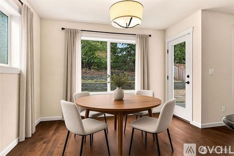 A dining room with a round table and chairs.
