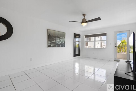 A spacious living room with a ceiling fan and a large painting on the wall.