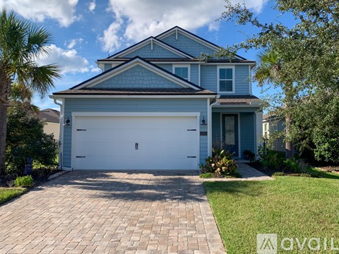 A two-story house with a garage and a driveway.