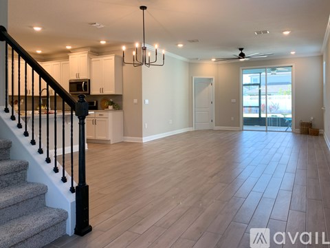 A spacious living room with a staircase leading to the upper floor.