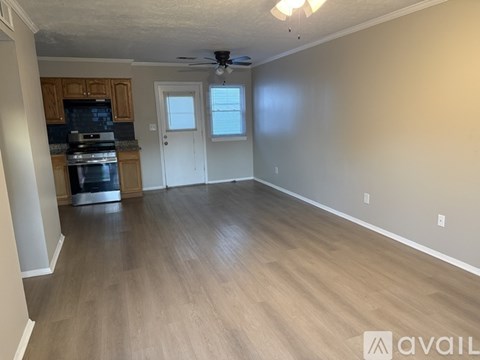A spacious living room with wood flooring and a ceiling fan.