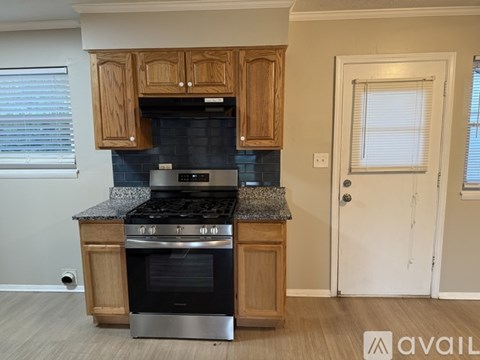 A kitchen with wooden cabinets and a black stove top oven.