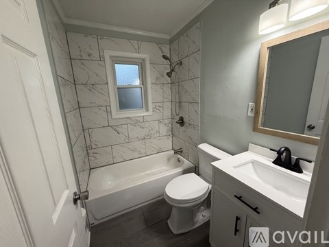 A bathroom with a marble tile wall and a white toilet.