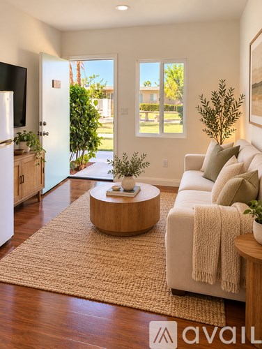 A living room with a couch, a coffee table, and a rug.