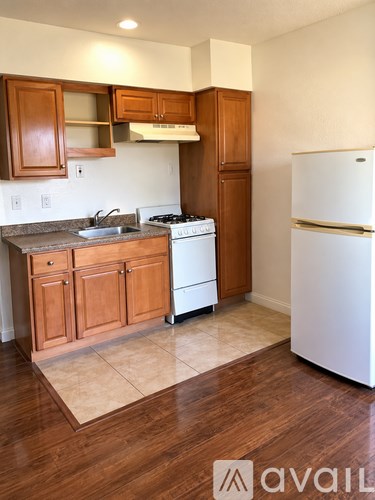 A kitchen with wooden cabinets and a white fridge.