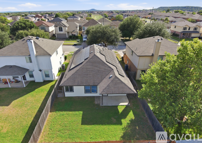 A house with a brown roof is surrounded by other houses.
