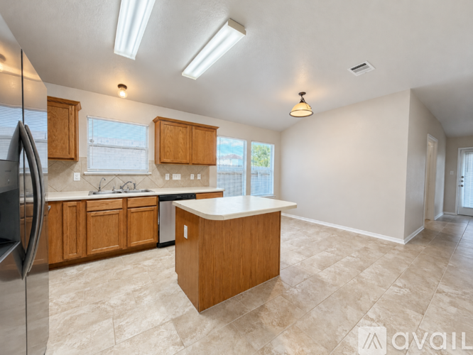 A kitchen with wooden cabinets and a central island.