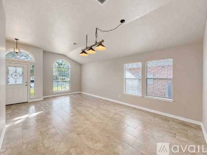 A spacious room with tiled flooring and a large window.