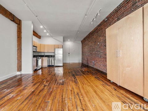 A room with wooden floors and a brick wall.