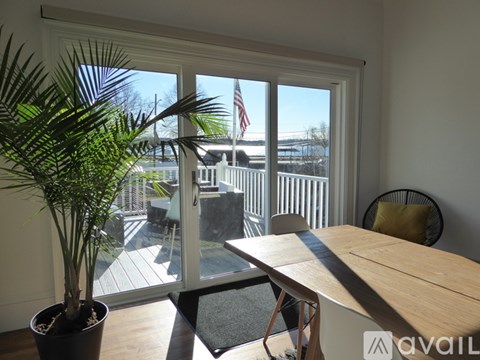 A room with a table, chairs and a potted plant.