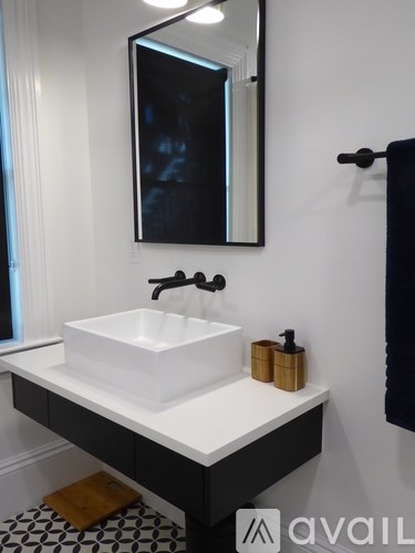 A white sink with a gold faucet and a mirror above it.