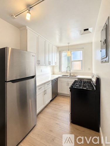 A kitchen with a stainless steel refrigerator and black dishwasher.