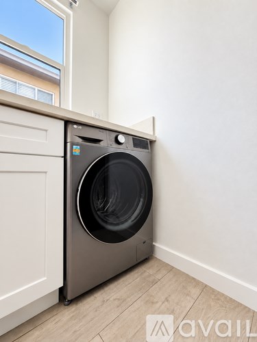 A washing machine is sitting in a corner of a room.